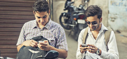 Friends standing next to their motorcycle sharing a good time