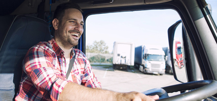 Truck driver smiling inside his truck