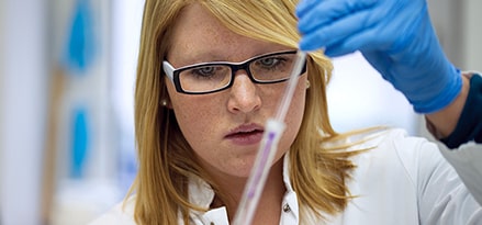 Woman in lab with beaker