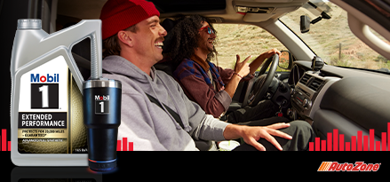 Two guys laughing while driving a car. Mobil 1 Extended Performance and Mobil 1 branded drink tumbler in the foreground.