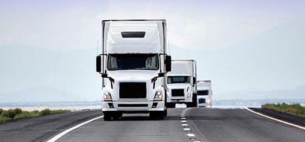 a fleet of trucks moves down the highway fueled by Mobil Delvac products and solutions