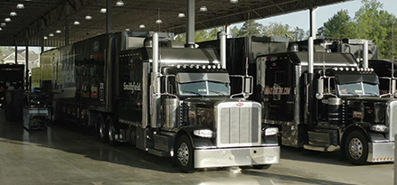 Two large trucks parked under overhang