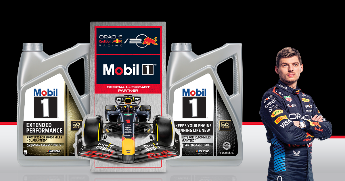 Bottle of Mobil 1 motor oil next to metal racing sign featuring dark blue, red and yellow Formula 1 race car.