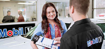 Technician walking customer through the advantages of getting oil change at Mobil 1 Lube Express℠